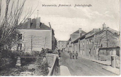 La rue de la gare de Warmeriville sur une carte postale ancienne