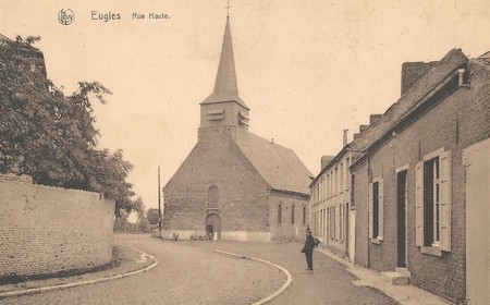 la rue haute et l'église à Eugies en Belgique sur une carte postale ancienne