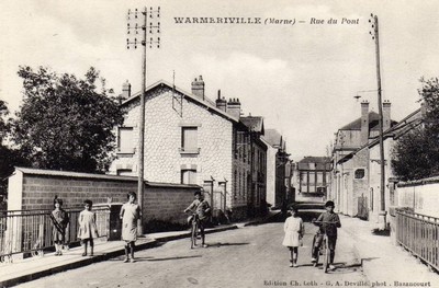 Le rue du pont à Warmeriville sur une carte postale ancienne